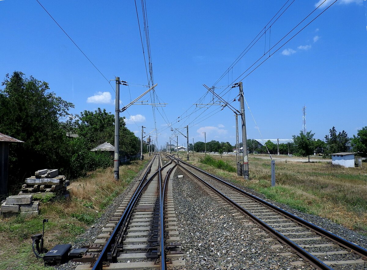Kreuzung der Bahnstrecke-702 mit Strada-Dolcesti in Bărăganul/Rumänien, anlässlich einer Fahrt bei  geöffnetem/freien Bahnübergang  aus einem Reisebus; 230706