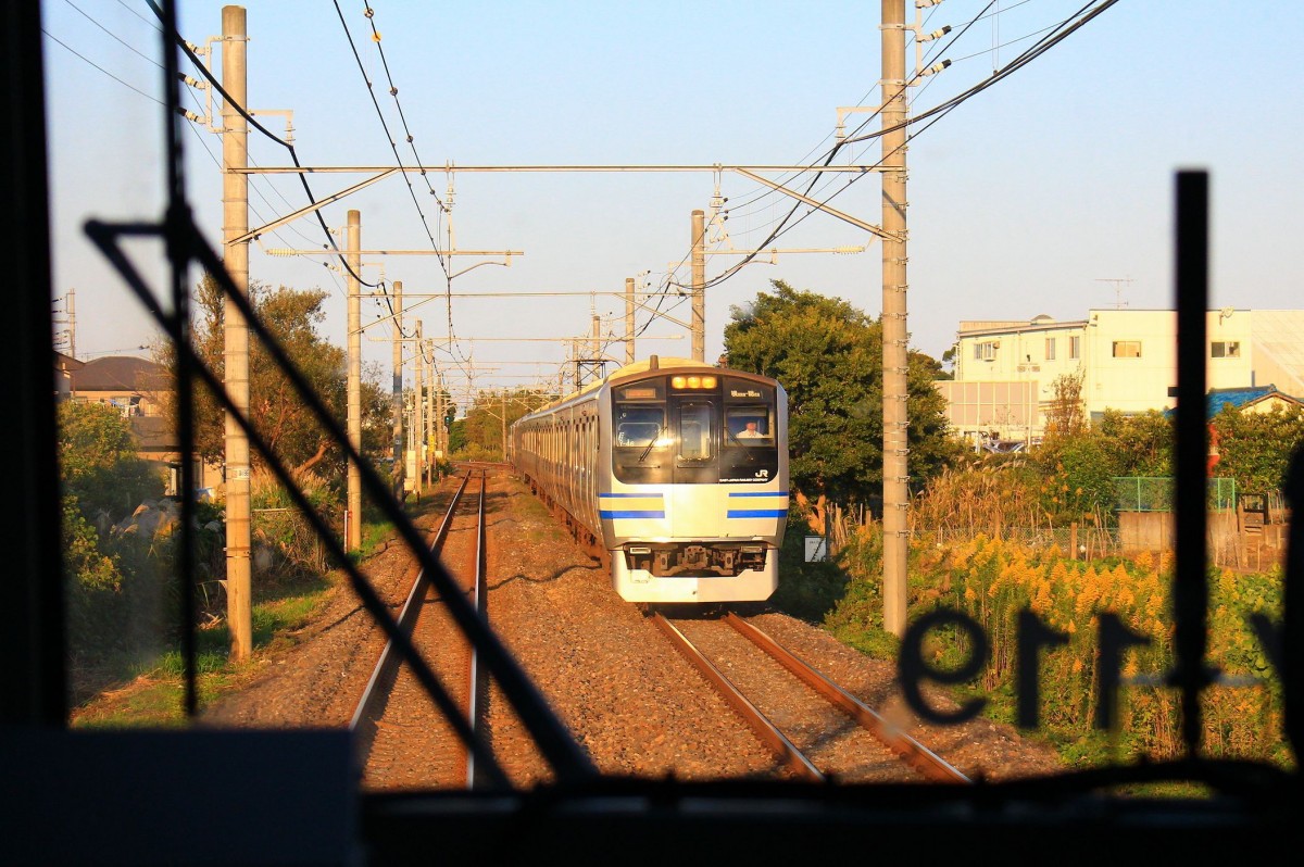 Kreuzung zweier Eilzge Serie 217: Aufnahme durch die verglaste Fhrerstand-Rckwand von Zusatzzug Nr. 19 (als Y-119 an der Frontscheibe angeschrieben). Entgegen kommt Zug Nr. 46 (Frontwagen kuha217-46). An der Bucht von Tokyo bei Anegasaki, 17.Oktober 2014. 