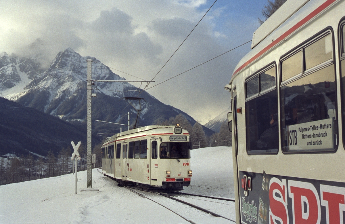 Kreuzung zweier ex-Hagener Düwag-Wagen, die in Innsbruck von Sechsachsern zu Achtachsern umgebaut wurden, in Telfer Wiesen, vor der Kuliss des 2700 Meter hohen Serles (März 2000).