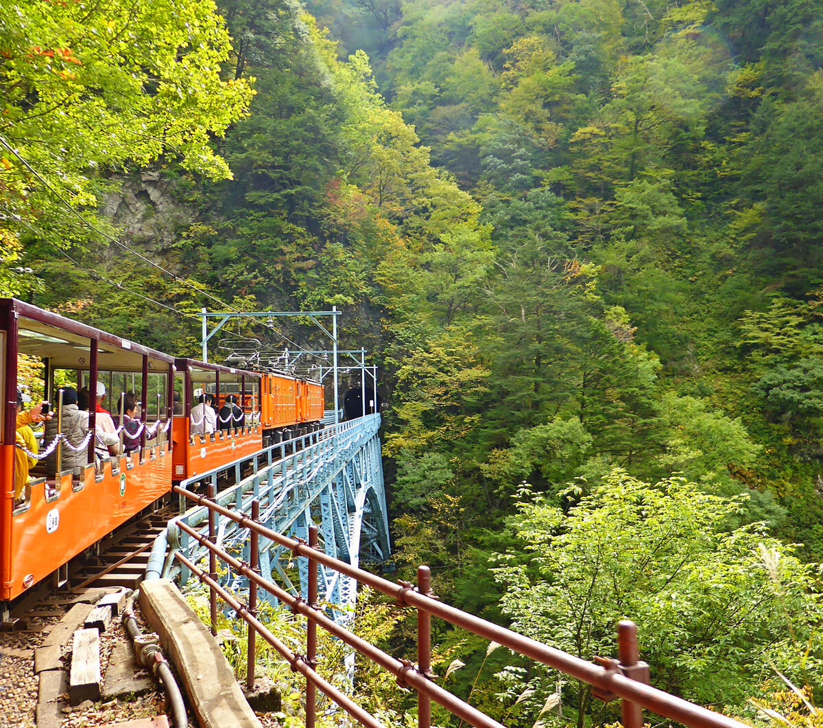 Kurobe Kyôkoku Tetsudô (Kurobe Gorge Railway): 762 mm Spur, 600 V Gleichstrom, Personenverkehr auf 20, 1 km Länge. 1923 Baubeginn der Elektrizitätswerke im Kurobe-Gebiet, 1937 Keyakidaira erreicht (heute Endstation für den Personenverkehr). 1953 öffentliche Bahn für Güter- und Personentransport, 1971 Tochtergesellschaft der Kansai-Elektrizitätswerke. 2024 durch Erdbeben und Erdrutsche beschädigt. Die wichtigsten Triebfahrzeuge sind Nr. 18 – 30 (nach Aenderungen, u.a. des Uebersetzungsverhältnisses, neu als EDR bzw. EDM bezeichnet), und neue Loks: EDM 31-32 (1990/91), EDR 33 (1994), EDV 34-37 (2011/12 gebaut). Bild: Ein Zug mit den Loks EDR 25 und 24 unterwegs in Kuronagi, 22.Oktober 2013 