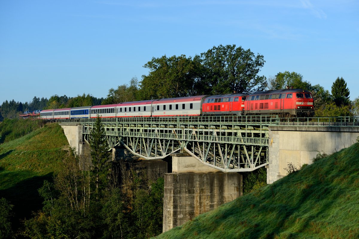 Kurz darauf kam EN 245 nach Bregenz über die fotogene Stahlbrücke bei Maria Thann gefahren. Bemerkenswert sind die beiden Doppelstock-Schlafwagen der Gattung WLABmz hinter den 218 499 und 491. Durch die Verspätung von ca. 90 Minuten lag der Zug am 24. September 2014 perfekt im Morgenlicht.