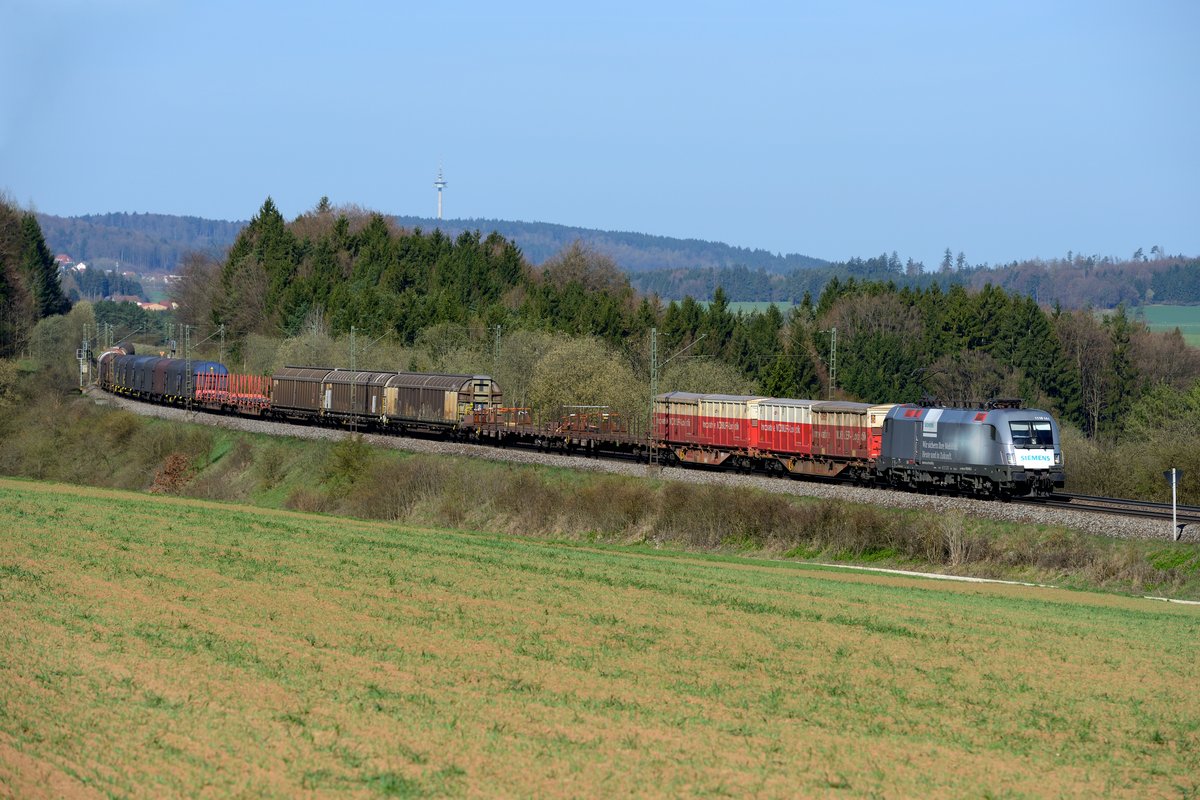Kurz darauf kam der nächste gemischte Güterzug in Richtung Österreich an der Fotostelle bei Darshofen vorbeigefahren. Auch auf der KBS 880 kann man gelegentlich einen Werbe-Tauurs der ÖBB beobachten. Am 15. April 2015 war es die 1116.141, welche in eigener Sache für ihren Hersteller Siemens wirbt. Im Hintergrund erkennt man übrigens den Fernmeldeturm Seubersdorf.