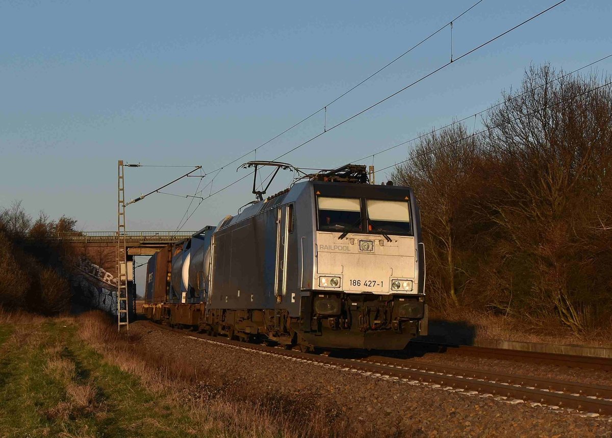 Kurz hinter der L116 Brücke kommt die 186 427-1 mit einm Klv die Noithausener Kurve hinauf am 19.3.2018 gen Rheydt gefahren. 