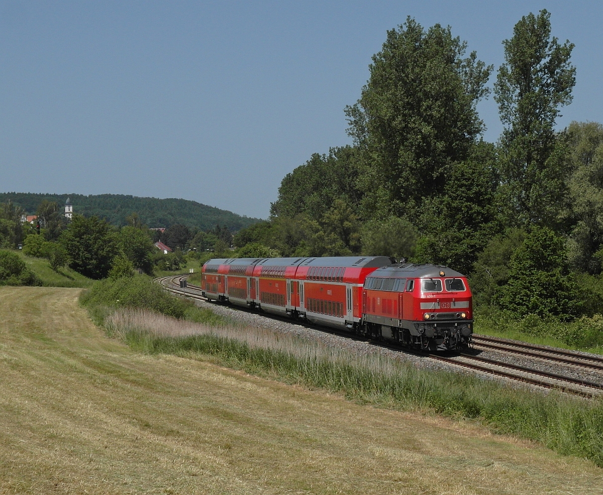 Kurz nach der Abfahrt in Aulendorf fährt 218 409-1 mit dem IRE 20777, Stuttgart - Friedrichshafen, bei Zollenreute am Fotograf vorbei. Auf Grund einer Gleisbaustelle in Biberach (Riß) und einer technischen Störung zwischen Geislingen (Steige) und Ulm fuhr dieser IRE am 08.06.2014 anstatt nach Lindau nur nach Friedrichshafen, hatte geänderte (Ab)Fahrzeiten und eine andere Zugnummer.