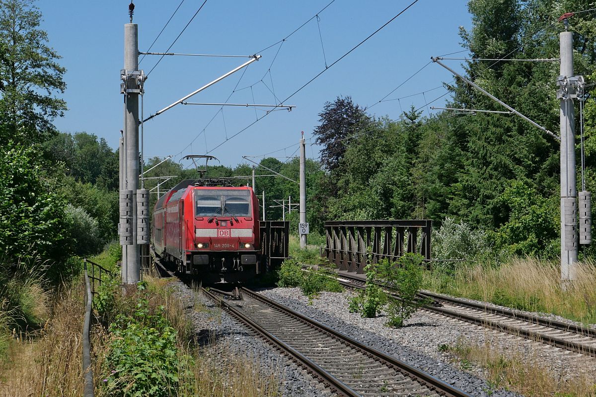 Kurz nach der Abfahrt in Aulendorf überquert am 25.06.2023 146 208-4 mit den Wagen des RE 5 / 4213, Stuttgart - Friedrichshafen, im Schussentobel bei Kilometer 159.0 die Schussen zum zweiten von insgesamt sieben Mal