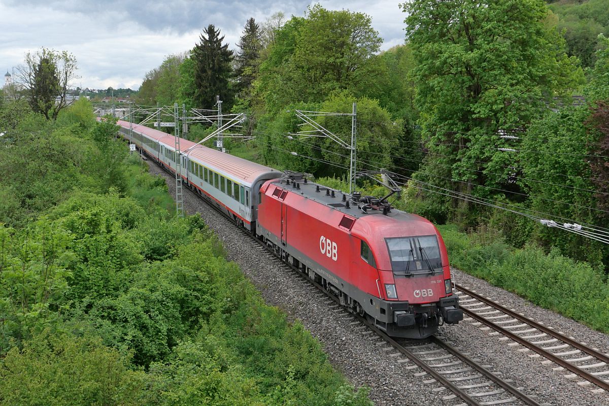 Kurz nach der Abfahrt in Biberach (Riß) werden die Wagen des IC 118  BODENSEE  von Innsbruck nach Dortmund von 1116 281 in Richtung Ulm gezogen (12.05.2023)