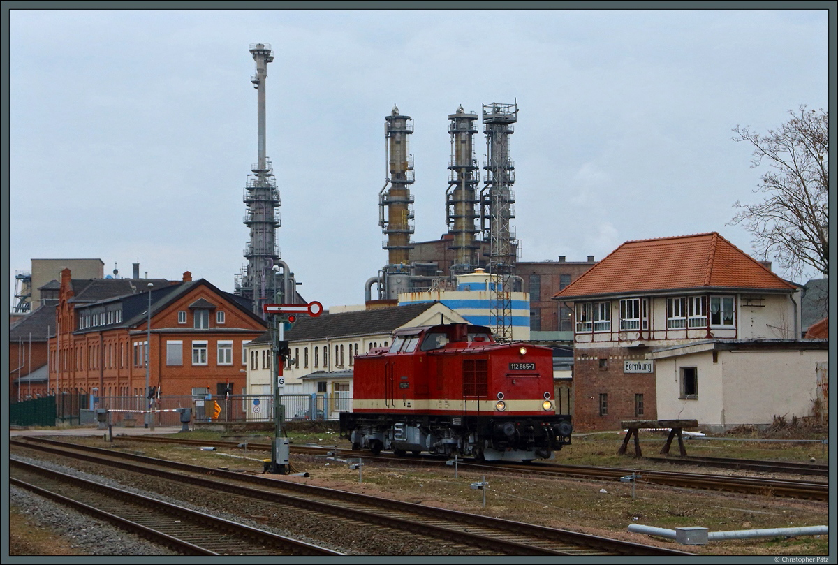 Kurz nach Ankunft mit ihrem Sonderzug aus Dessau setzt 112 565-7 vor der beeindruckenden Kulisse des Sodawerkes Bernburg um. Dabei passiert sie das mechanische Wärterstellwerk W3, das den nördlichen Bahnhofskopf steuert. Das kleine Ausfahrsignal G wurde sogar kürzlich erneuert. (02.03.2019)