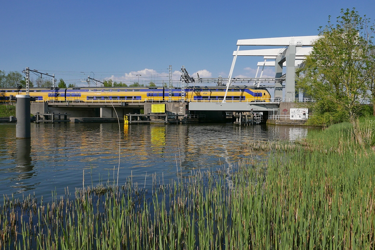 Kurz nach dem Passieren des Bahnhofs von Weesp befindet sich am 07.05.2016 ein Triebzug der Baureihe VIRM  Regiorunner  auf der Fahrt von Nijmegen nach Den Helder.