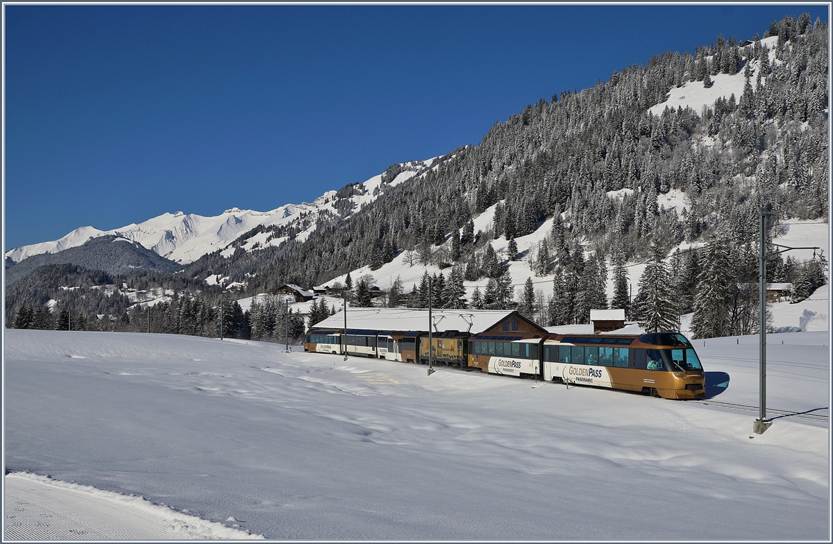 Kurz nach Gruben ist der MOB Paradezug Parnoramic Express 2118 vom Montreux nach Zweisimmen unterwegs. In der Mitte des Zuges schiebt und zieht die MOB GDe 4/4 6003  Train du Chocolat .
13. Feb. 2018
