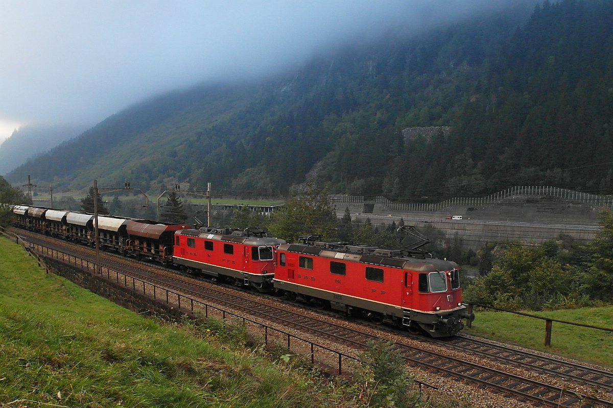 Kurz nach Verlassen des Pfaffensprungspiraltunnels zwischen Gurtnellen und Pfaffensprung ziehen zwei Re 4/4 II einen Schüttgutwagenzug am 30.09.2015 Richtung Göschenen.