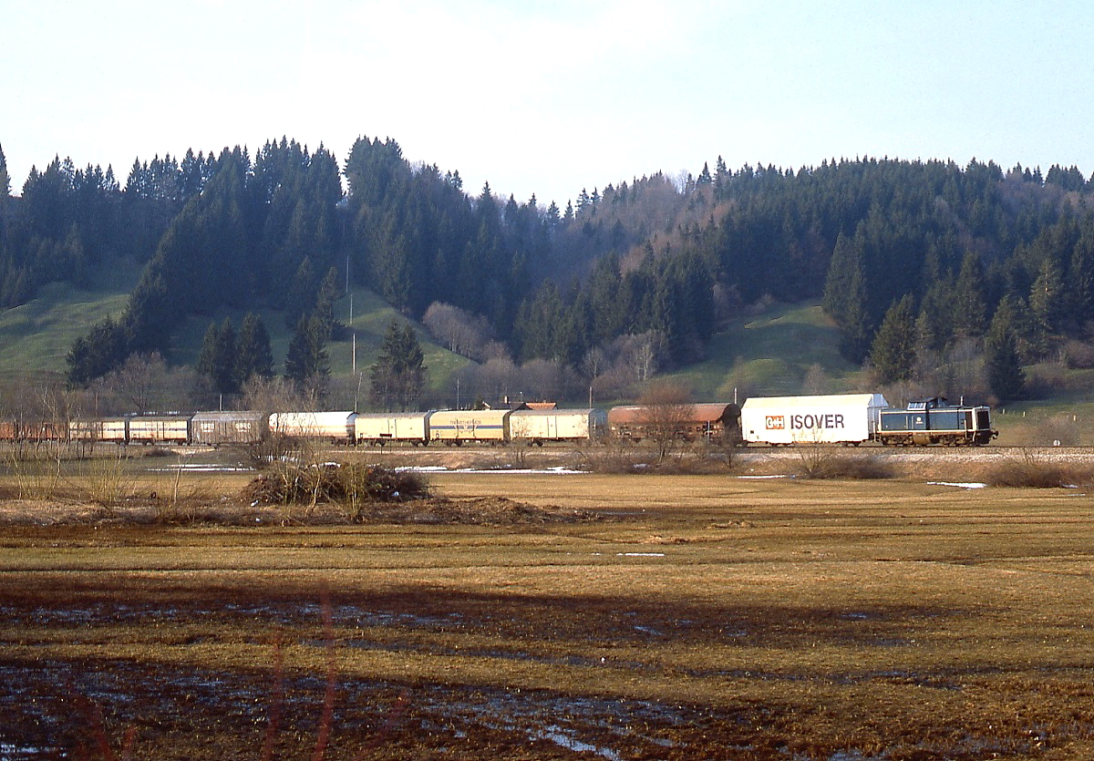Kurz vor Bühl am Alpsee ist eine unbekannte 212 mit einem Güterzug im April 1982 unterwegs