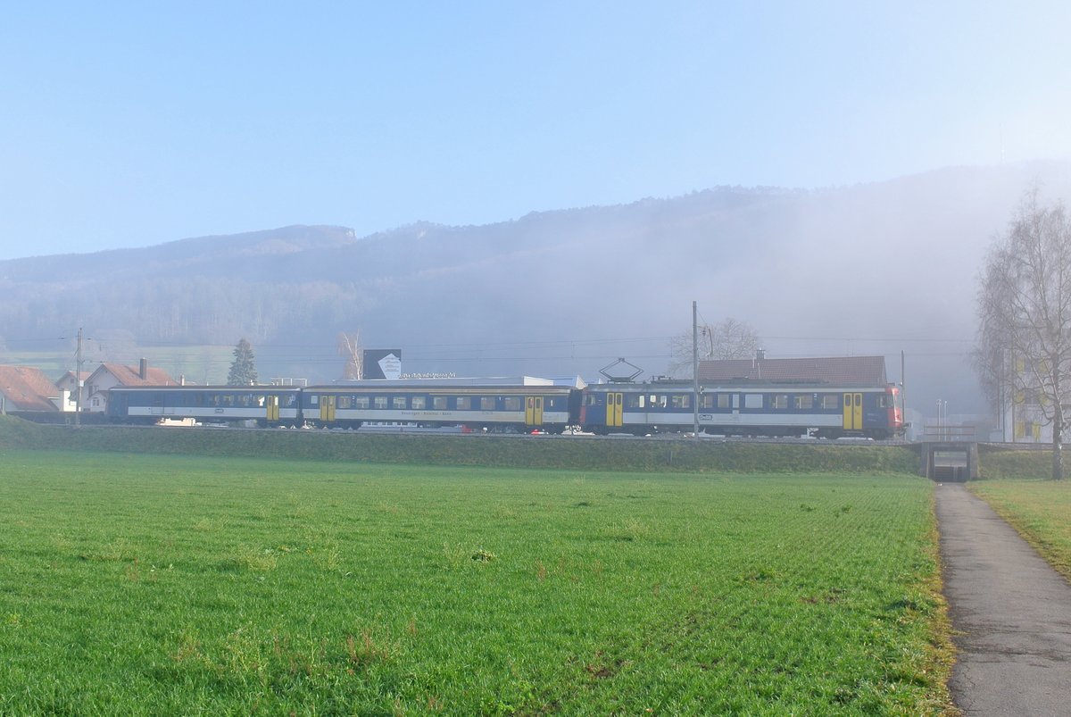 Kurz vor dem Ausscheiden der RBe aus dem Plandienst bei den OeBB; Balsthal, 07.12.2015: Der Regio nach Balsthal bestehend aus dem RBe 205, AB EWII 505 und BDt EWI 905 taucht kurz vor Balsthal aus dem nebel aus und fhrt der Sonne entgegen. 