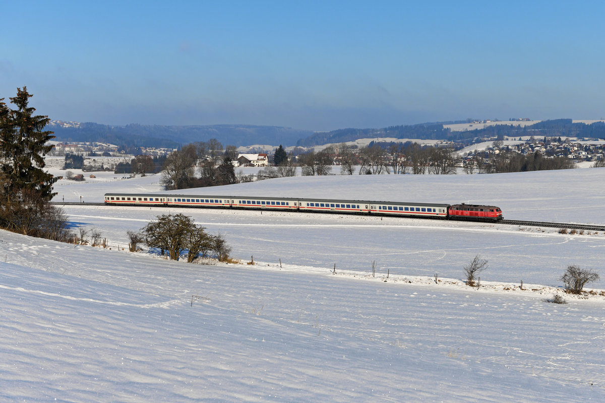 Kurz vor dem Bahnhof Günzach konnte ich am 10. Januar 2021 die etwas blasse Ulmer 218 481 mit dem IC 2084  Nebelhorn  aufnehmen. Im Hintergrund erkennt man den Markt Obergünzburg. Endlich war der Winter eingekehrt und die Landschaft zeigte sich verschneit. 