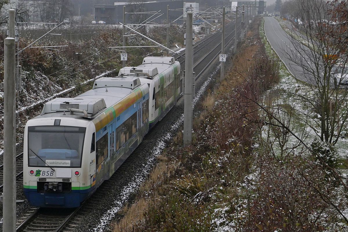 Kurz vor dem nächsten Halt, Friedrichshafen-Flughafen, befinden sich VT 006 (650 033-3) und VT 004 (650 031-7) der  Breisgau S-Bahn  als RB 91 / 87571 auf der Fahrt von Aulendorf nach Friedrichshafen Hafen (26.11.2021)