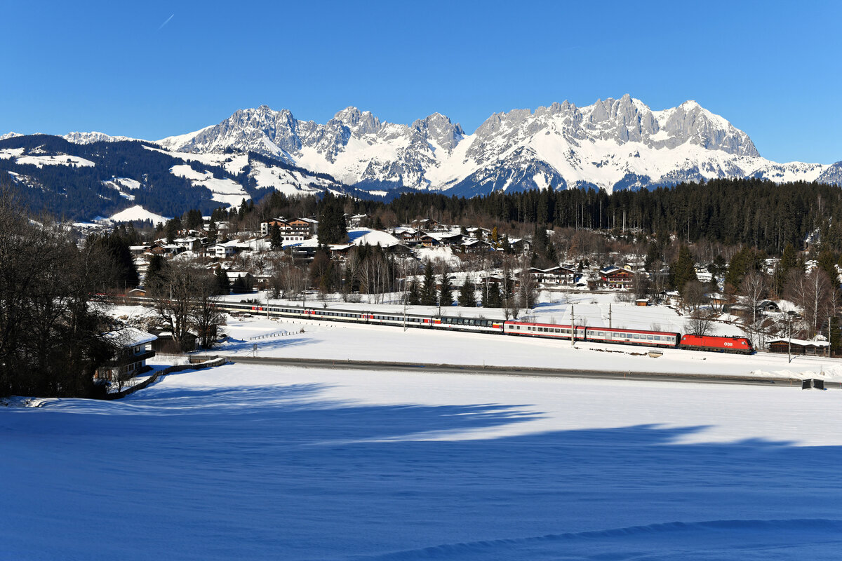 Kurz vor Kitzbühel ergibt sich dieser Blick auf den Gebirgszug des Wilden Kaisers. Am 12. Februar 2022 konnte ich dort die 1016.030 mit dem EC 163  Transalpin  auf der Fahrt nach Graz aufnehmen. Die Wetterbedingungen und Schneeverhältnisse waren an diesem Tag als traumhaft zu bezeichnen.