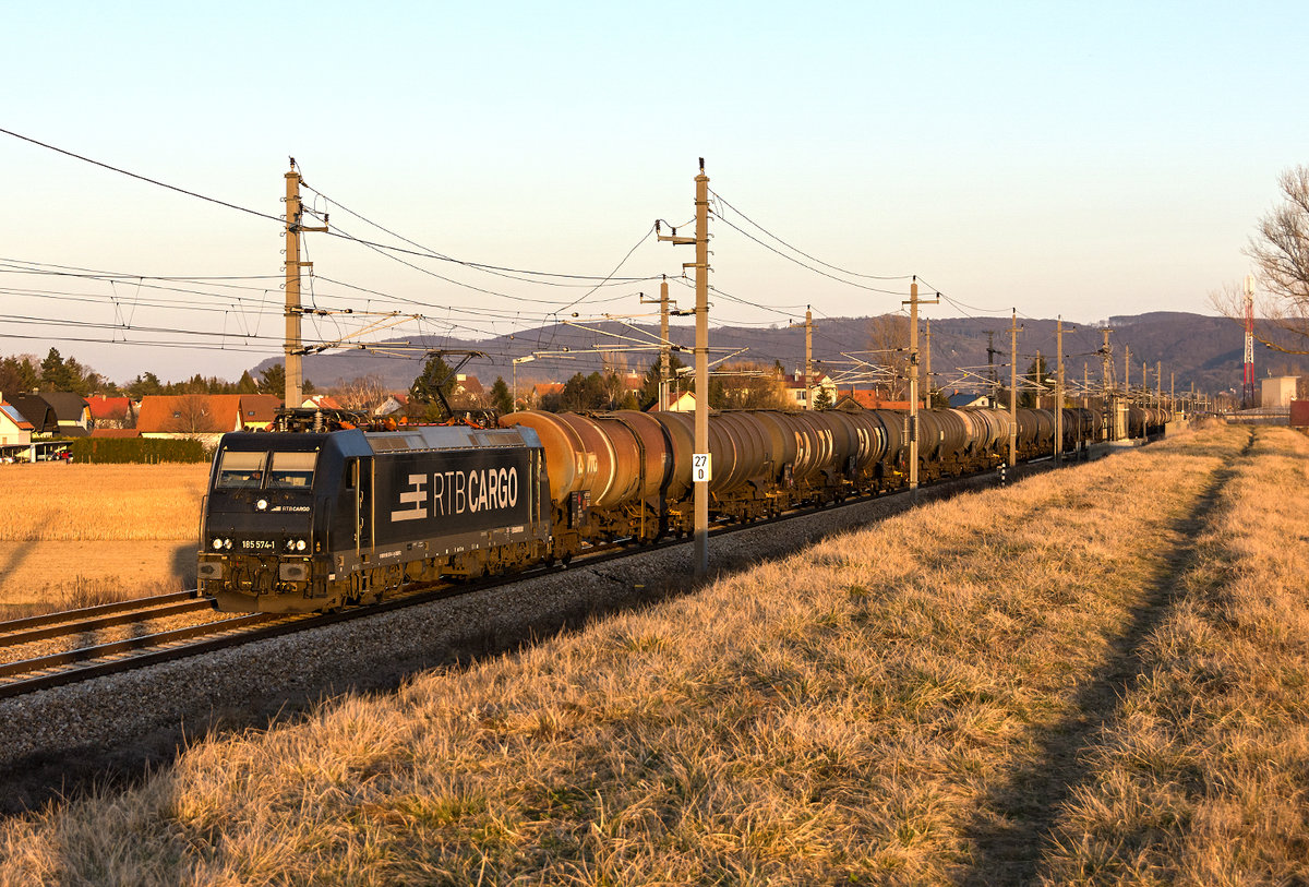 Kurz vor Sonnenuntergang kam dieser Kesselwagenzug mit der BR 185 574 bei Muckendorf- Wipfing vorbei. Die Aufnahme entstand am 27.02.2019.
