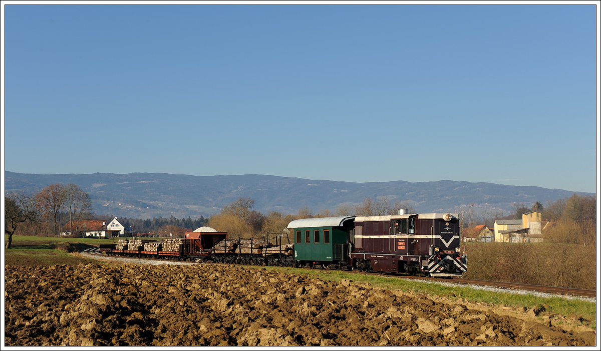 L45H-070 mit ihrem Güterzug am 5.12.2015 auf der Fahrt von Stainz nach Preding kurz nach der Haltestelle Ölmühle Herbersdorf, welche links am Bild zu sehen ist.