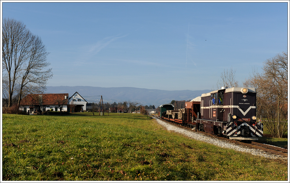 L45H-070 mit ihrem Güterzug am 4.12.2015 auf der Fahrt von Stainz nach Preding kurz nach der Haltestelle Ölmühle Herbersdorf, welche links am Bild zu sehen ist.