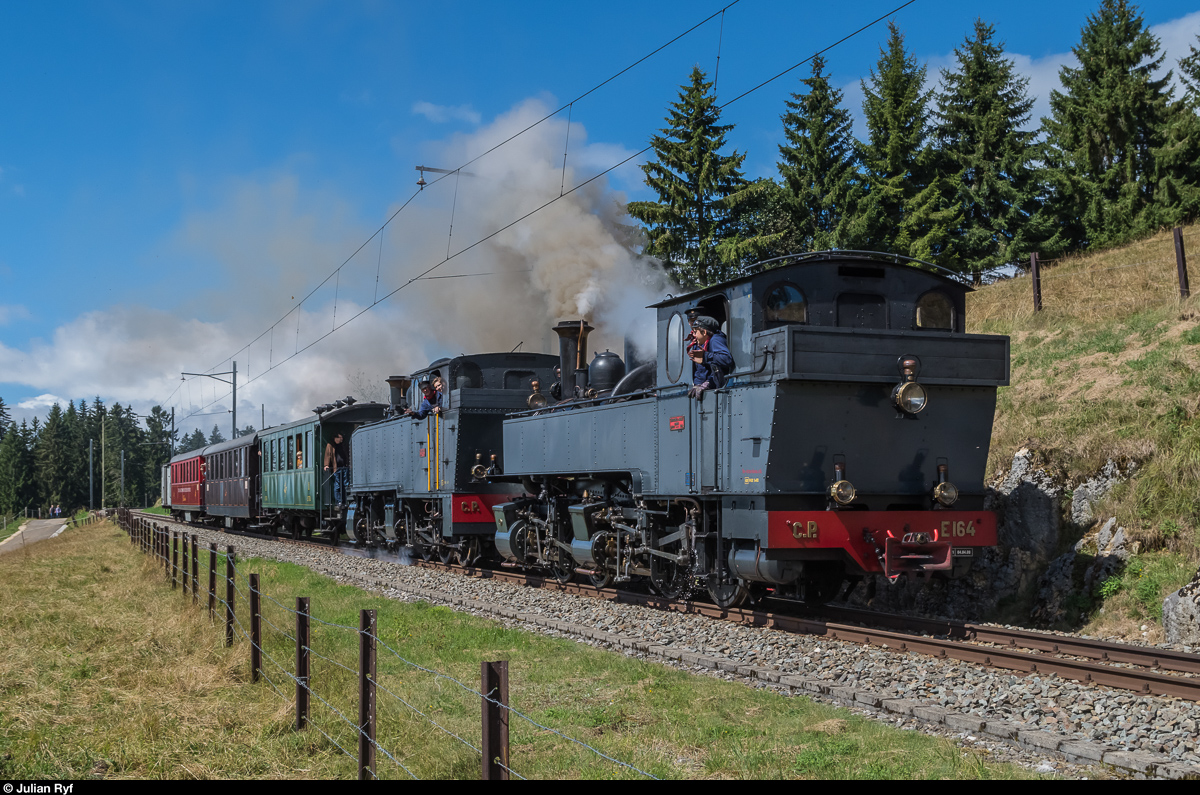 La Traction Dampf-Doppeltraktion am 21. August 2016: Die G 2x2/2 E 164 und die G 2/3+3/3 E 206 fahren bei La Chaux-des-Breuleux talwärts. Durch den Pfiff der beiden Loks haben sich die Kühe und Pferde leider aus dem Staub bzw. aus dem Bild gemacht.