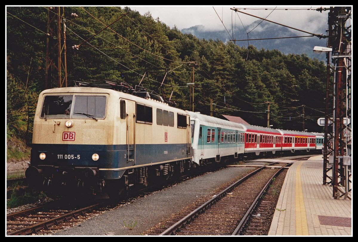 Lange Zeit gehörte die DB - Reihe 111 zum alltäglichen Erscheinungsbild der Mittenwaldbahn.    111 005 ist am 18.05.2000 mit R5414 im Bahnhof Hochzirl zu sehen. Als Besonderheit ist bei diesem Bild anzumerken das sich Steuerwagen und Lok an der Zugspitze befinden. Betriebsintern wird so ein Zug WU (Wendezug untauglich) bezeichnet.