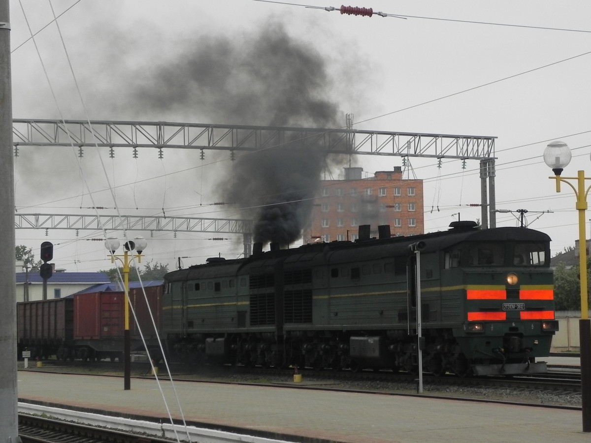 Leider hatte es nur noch zu einem Teleschuss über die Bahnsteige hinweg gereicht. Die 2TE1011-3612 fährt mit einem Güterzug von Süden kommend durch den Bahnhof Gomel. 28.05.2015 um 12:25 Uhr. 