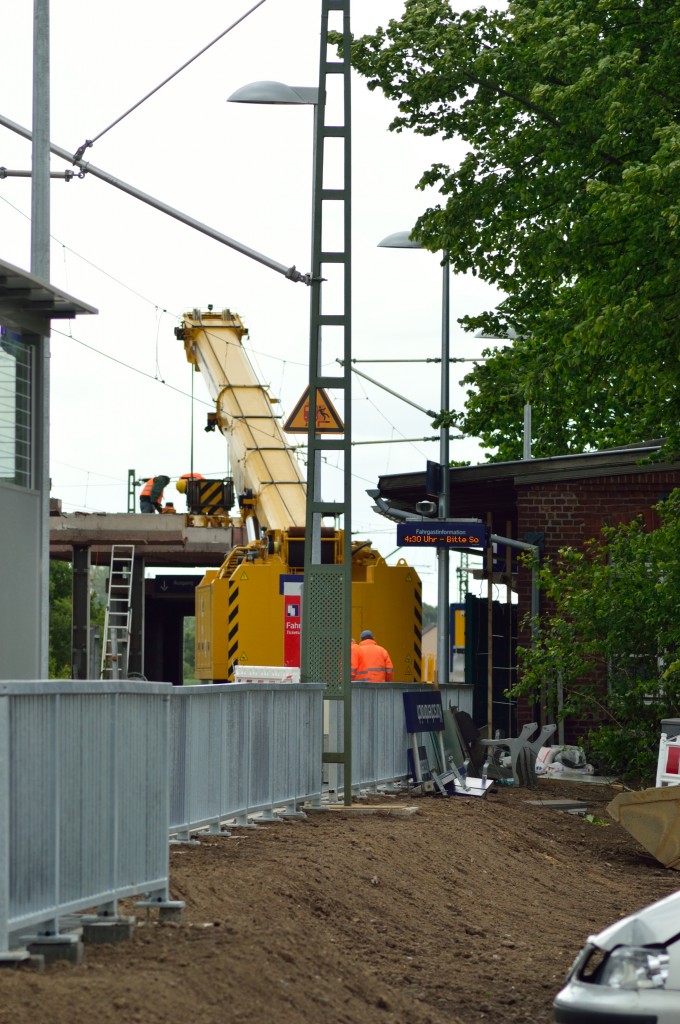 Leider kam man nicht näher an die Baustelle heran, wo gerade ein Schienenkran das letzte Bahnsteigdachstück angeschlagen bekommt. Im Vordergrund ist das Schutzgitter des neuen Seitenbahnsteigs zu erkennen. Sonntag den 11.5.2014