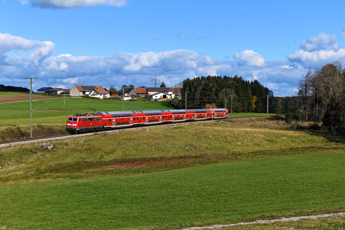 Leider nur ein Jahr lang dauerten die Einsätze der Baureihe 111 ins Unterallgäu auf der neu elektrifizierten Strecke nach Memmingen. Inzwischen hat das private Unternehmen GoAhead die Regionalzugleistungen von der Deutschen Bahn übernommen und setzt hierfür Triebwagen aus dem Hause Stadler ein. Wenige Wochen vor der Umstellung konnte ich am 23. Oktober 2021 die 111 065 mit dem RE 57410 auf der Fahrt nach Memmingen bei der kleinen Ortschaft Grabus aufnehmen. Durch den Bau einer Straßenbrücke und die Fällung von Bäumen ist diese Fotostelle neu entstanden.
