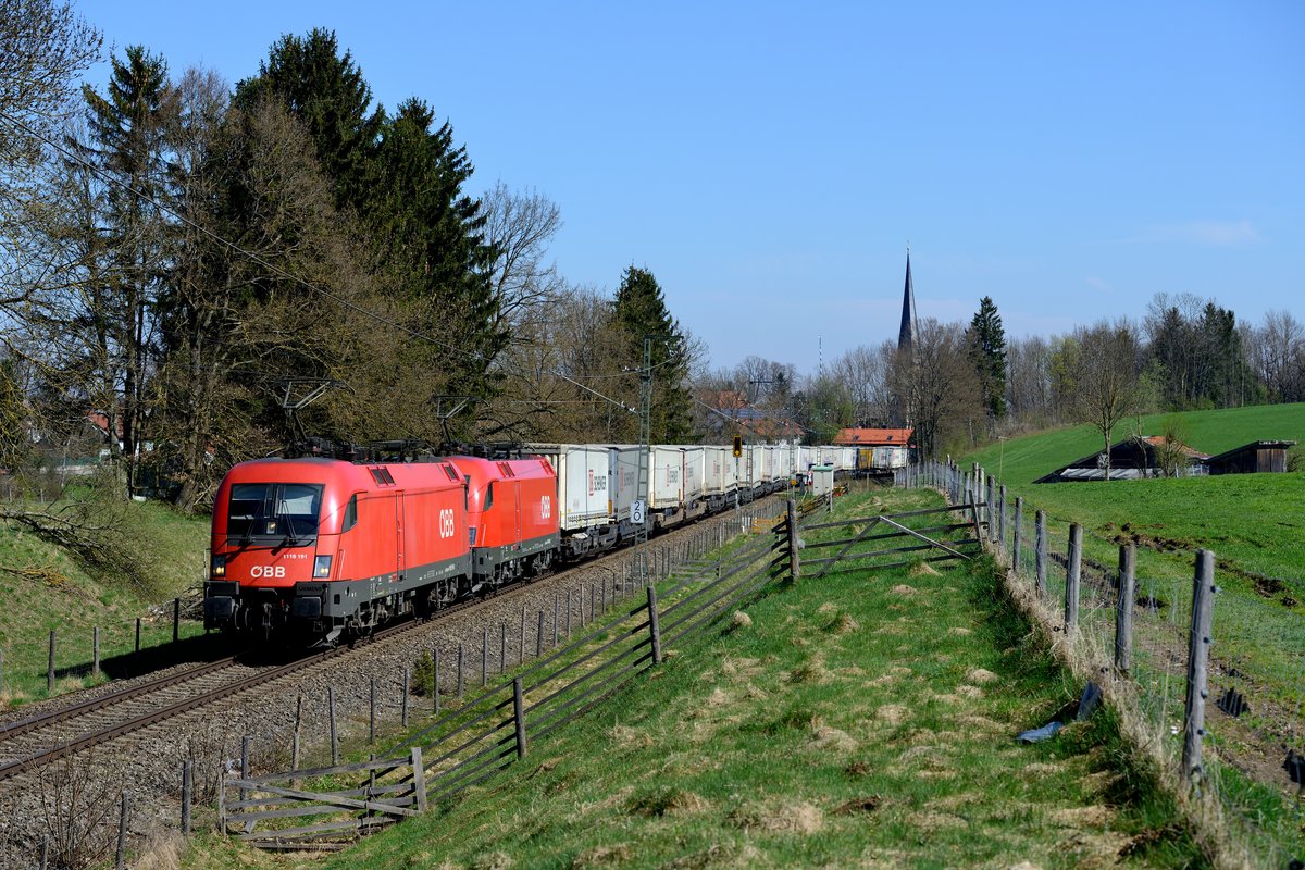 Letzter über die Mangfalltalbahn umgeleiteter Zug des Tages war der KT 42156 von Verona Q.E. nach Rostock Seehafen. 1116.191 und eine Schwestermaschine brachten den Zug bis nach München Laim, dort wurde dann auf eine DB Lok umgespannt. Aufgenommen wurde das fotogene Tandem bei Föching (19. April 2015).