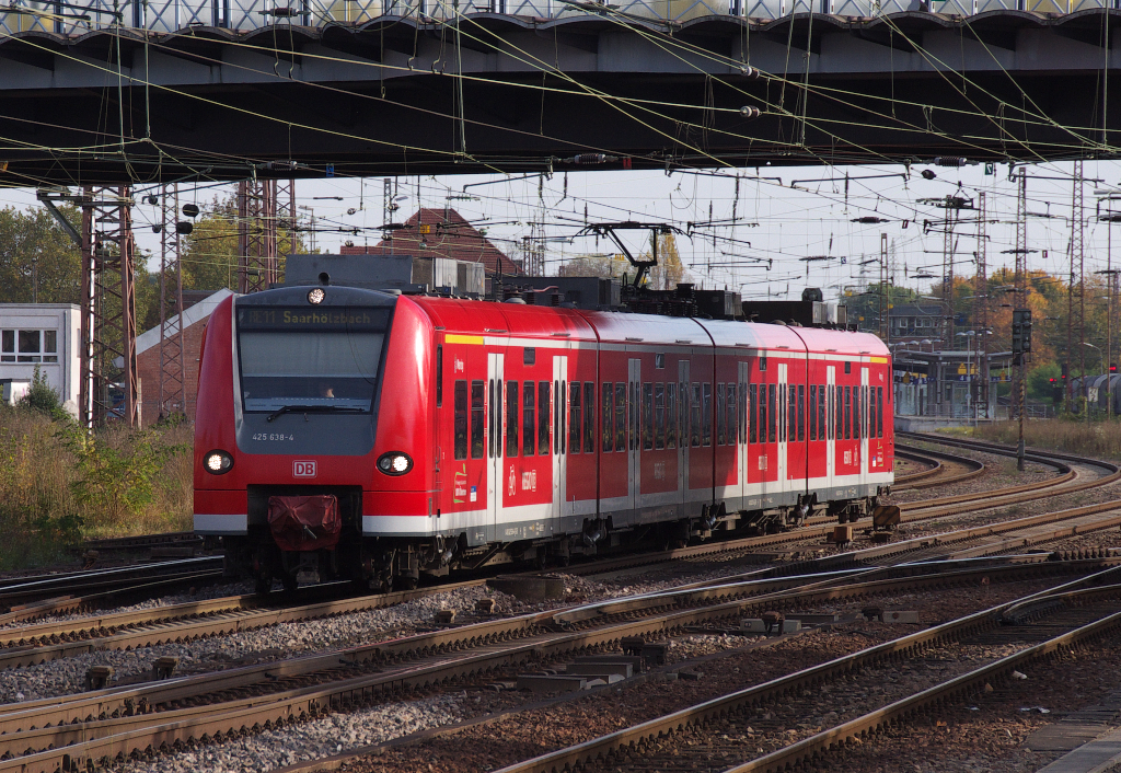 Licht und Schatten wechseln sich ab als 425 138 unter der Br�cke an der Nordausfahrt des Dillinger Bahnhofes hindurch f�hrt. Der RE nach Saarh�lzbach beschleunigt in Richtung Merzig. 22.10.2013 - Bahnstrecke 3230 Saarbr�cken - Karthaus.