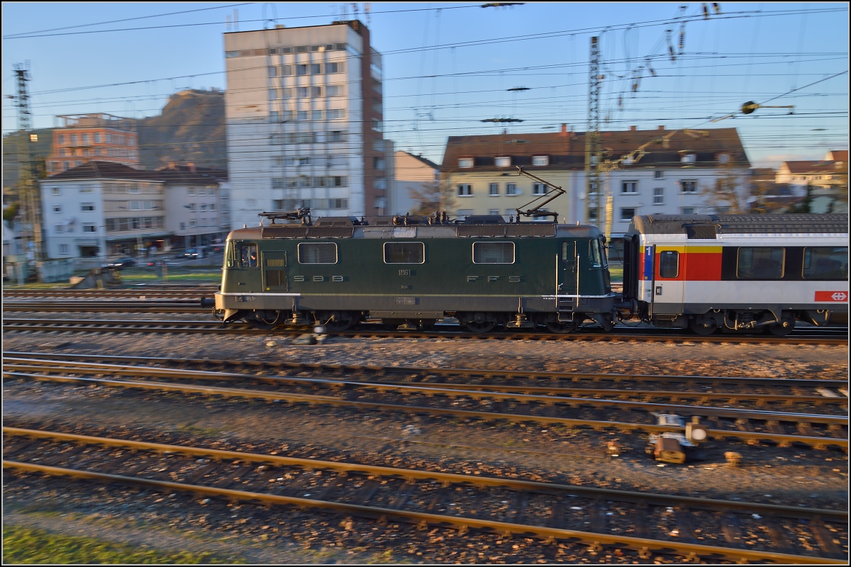 Lichtspiele in Singen am Hohentwiel. 

In originalen Grün präsentiert sich die Re 4/4<sup>II</sup> 11161 vor dem IC 187 Stuttgart-Zürich. November 2013.