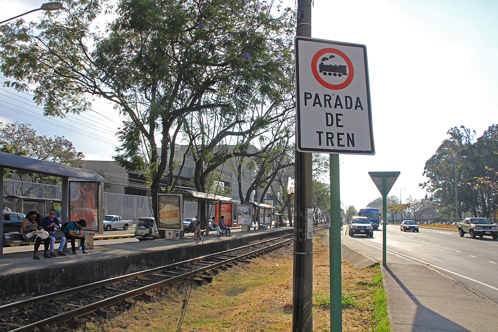 Linie des Agglomerationsverkehrs Incofer mit Haltestelle Contraloría in San José. Die Tafel weist auf einen unbewachten Bahnübergang hin. Aufnahme vom 09. April 2014, 16:06
