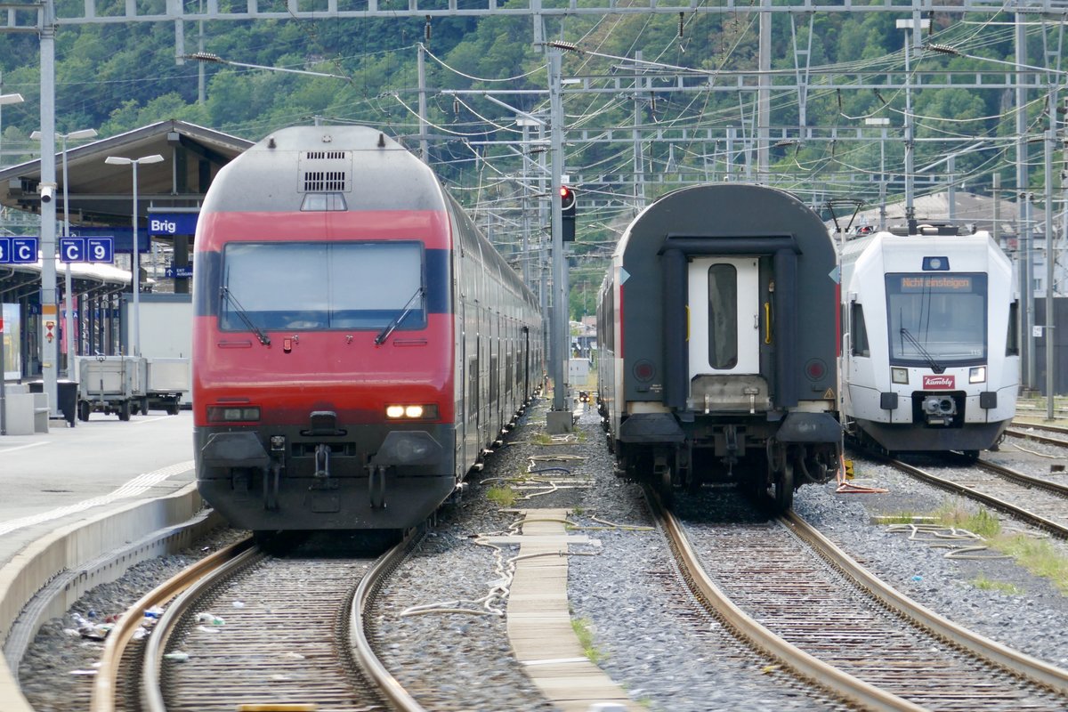 Links der IC 6 nach Basel, abgestellte Wagen und der Kambly-Lötschberger 115  Trubschachen 2  der da abgestellt wurde, am 23.7.18 im Bhf Brig.
