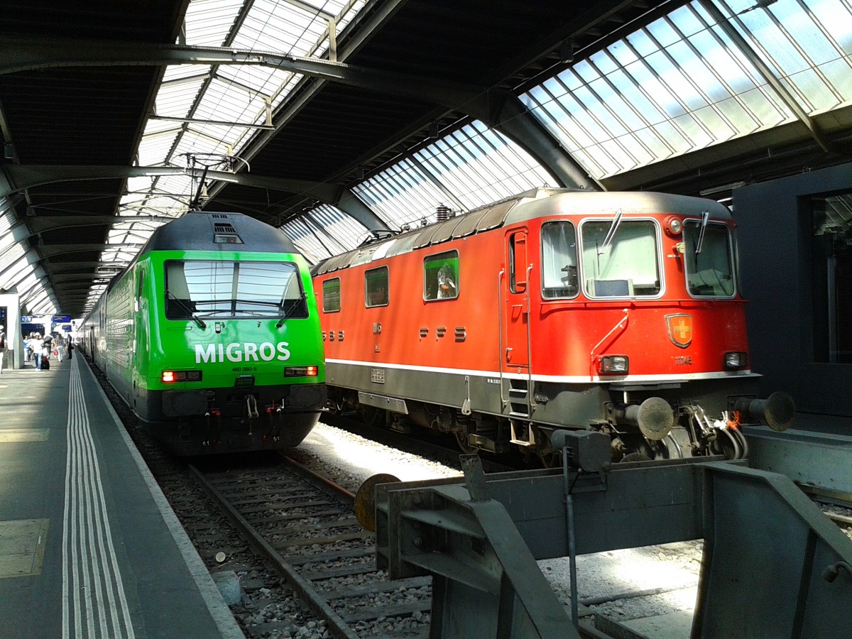 Links die Re 460 080-5  MIGROS  am Zugschluss des IR 2645 (Zürich Flughafen - Zürich HB - Zug - Luzern) und rechts die Re 4/4 II 11145 mit IC 920 (Chur - Zürich HB) am 24.7.2015 in Zürich HB.
