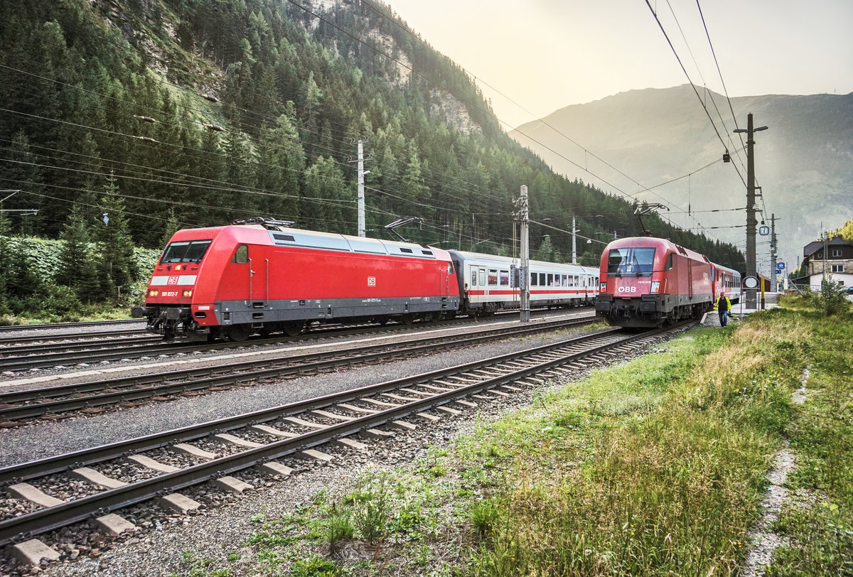 LINKS:
101 072-7 durchfährt mit dem EC 115 (Münster (Westf) Hbf - Klagenfurt Hbf) den Bahnhof.

RECHTS:
1016 029-1 trifft mit der ASTB 9626, aus Mallnitz-Obervellach, ein.

Aufgenommen am 30.8.2017, in Böckstein.