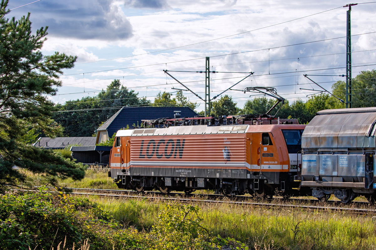 LOCON Lok 189 821 mit dem ersten Teil des Kreidezuges nach Bergen durchfährt den Bahnhof Lietzow bei etwas Gegenlicht. - 31.08.2022
