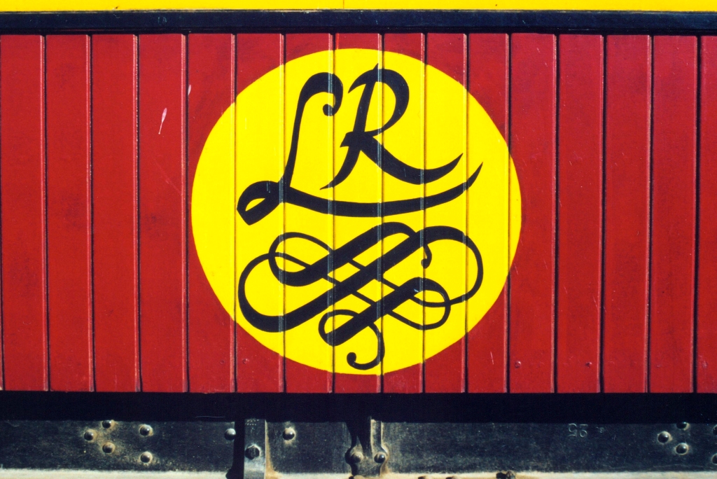 Logo des  Lézard Rouge  (französisch Rote Eidechse), angebracht auf dem SNCFT YDP-6705. Der Wagen ist Teil des Touristenzuges  Lézard Rouge  und war ursprünglich im Besitz des Bey von Tunis. Bild vom Morgen des 29.Dezember 2001 im Gare de Metlaoui. (Fotoscan)