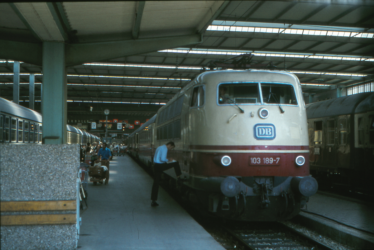 Lok 103 189 der Deutschen Bundesbahn steht abfahrtbereit mit dem IC  Südwind  im Münchner Hauptbahnhof. Ziel des Zuges ist Bremen Hbf. Ab dem Sommerfahrplan 1978 führte dieser Zug, der München in der Stunde zwischen 12 und 13 Uhr verließ, auch Waggons der zweiten Wagenklasse. Es war meine erste Fahrt in einem Intercity der Deutschen Bundesbahn und sie sollte mich gleich von München bis nach Göttingen führen. Ich erinnere mich, daß ich sehr stolz auf diese Fahrt war. Der Schaffner erstellt gerade den Bremszettel für die Lokomotivführer - Züge mit einer Geschwindigkeit von über 160 km/h wurden damals von zwei Lokführern besetzt. 
München Hbf, 16. August 1978