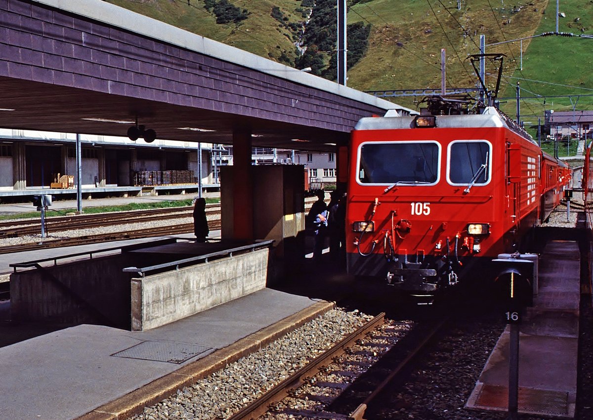 Lok 105 (GE 4/4 II) der Furka Oberalp-Bahn steht im Sommer 1993 mit einem Glacier-Express im Bahnhof Andermatt.
Dia- Aufnahme digitalisiert.