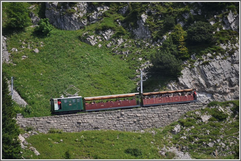 Lok 12 mit den Sommerwagen auf Bergfahrt an der Stepfegg. Der Lokfhrer geniesst das herrliche Panorama. (06.07.2013)