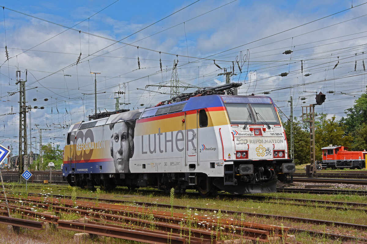 Lok 185 589-9 mit der Werbung  500 Jahre Reformation , steht auf einem Abstellgleis beim badischen Bahnhof. Die Aufnahme stammt vom 18.08.2021.