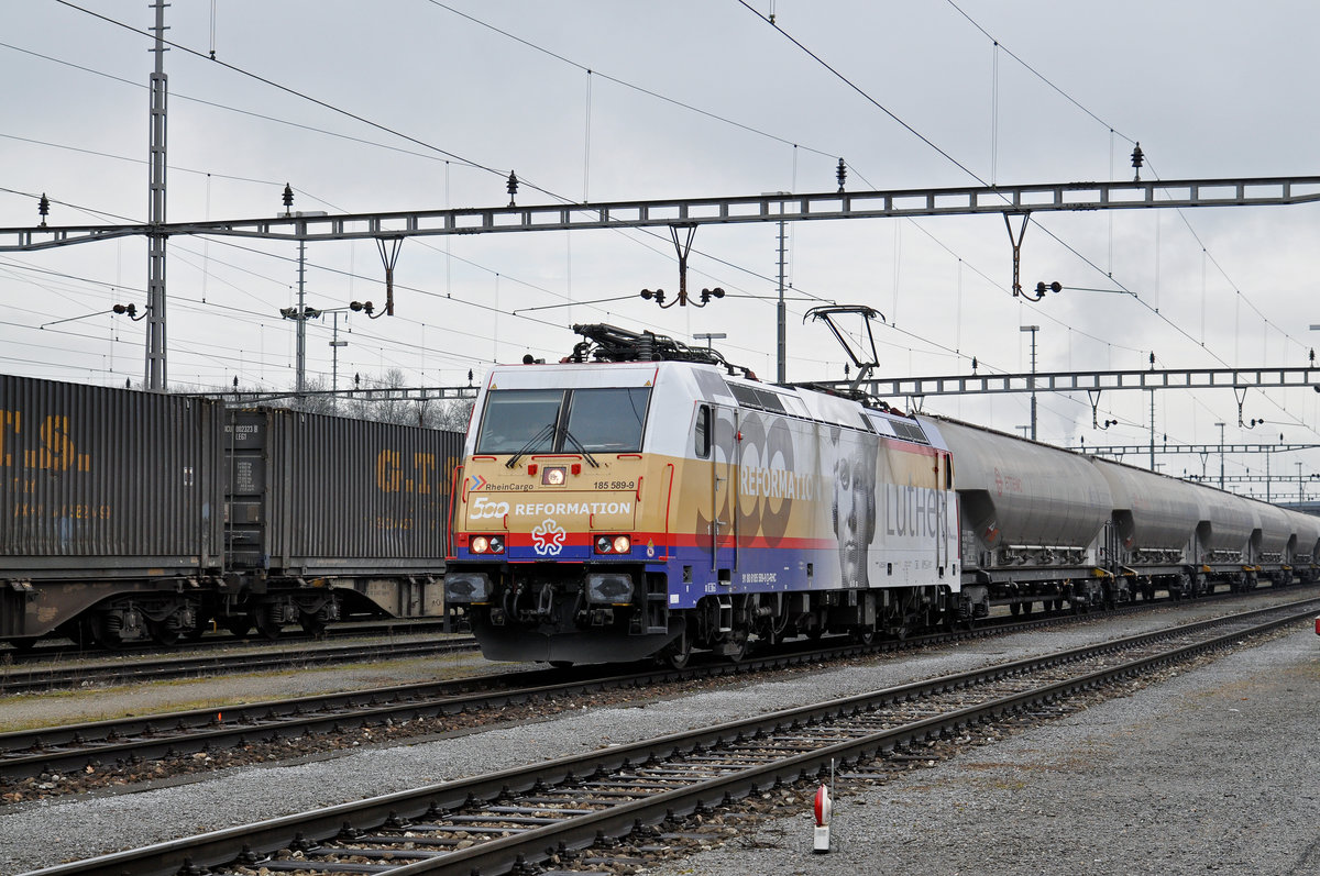 Lok 185 589-9, mit einer Werbung für die 500 Jahre Reformation von Martin Luther, durchfährt den Güterbahnhof Muttenz. Die Aufnahme stammt vom 06.02.2017.