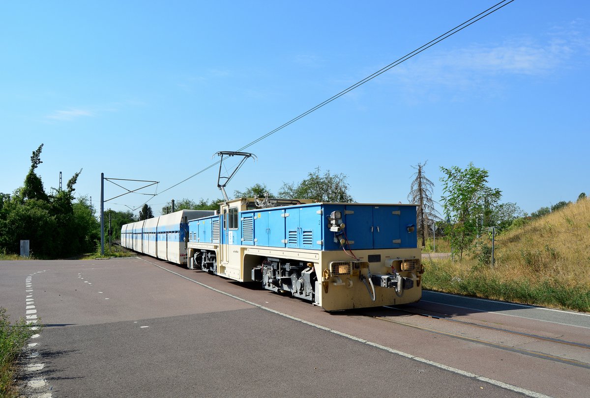 Lok 2 der Sodabahn Bernburg kommt vom Sodawerk kommend gefahren und unterquert auf dem Weg in den Verladebunker in Kürze die B185. Gebaut wurden die beiden Loks 2006 bei der Schalker Eisenhütte. Betrieben werden sie mit 600V. 

Bernburg 31.07.2018