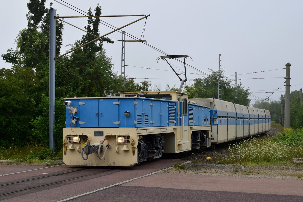 Lok 2 der Sodabahn Bernburg überquert den einzigen BÜ der kurzen Strecke und taucht dann ins Bergwerk unter.

Bernburg 06.08.2021