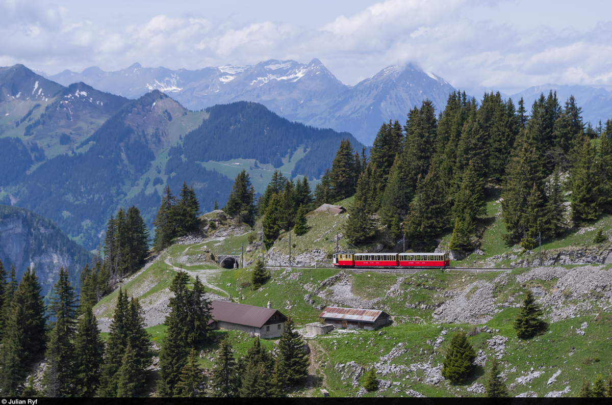 Lok 20 der Schynige Platte Bahn schiebt am 31. Mai 2015 kurz nach dem Grätli-Tunnel zwei Vorstellwagen in Richtung Bergstation Schynige Platte. Darüber im Hintergrund der Niesen, dessen Spitze in den Wolken liegt.