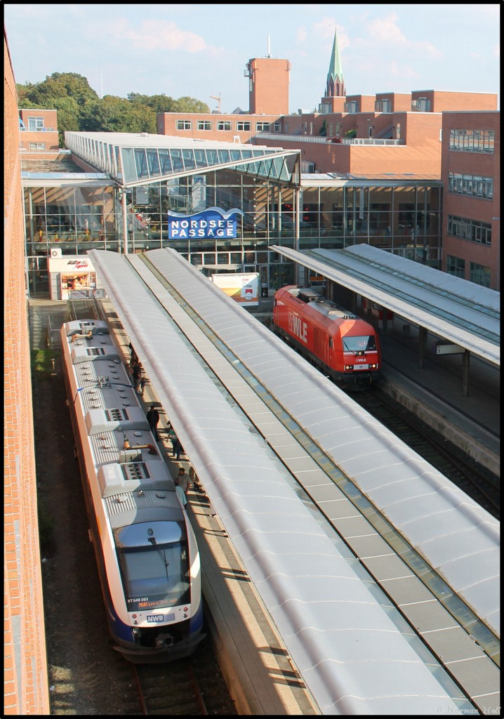 Lok 23 der WLE hat sich soeben von Ihrem Sonderzug am Gleis 2 gelöst um ihn zu Umfahren.
Links VT648 083 der NWB, kurz vor seiner Ausfahrt von Wilhelmshaven nach Esens. 19/09/2014