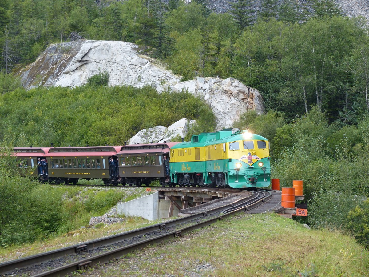 Lok 91 zieht den langen Touristenzug am 16.08.2013 talwrts in Richtung Skagway. Der Zug hat hier bereits die Grenze nach Alaska berquert, die sich auf dem White Pass befindet.