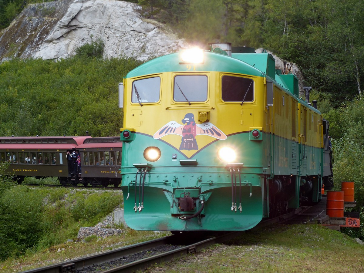 Lok 91 zieht den langen Touristenzug am 16.08.2013 talwrts in Richtung Skagway. Der Zug hat hier bereits die Grenze nach Alaska berquert, die sich auf dem White Pass befindet.
