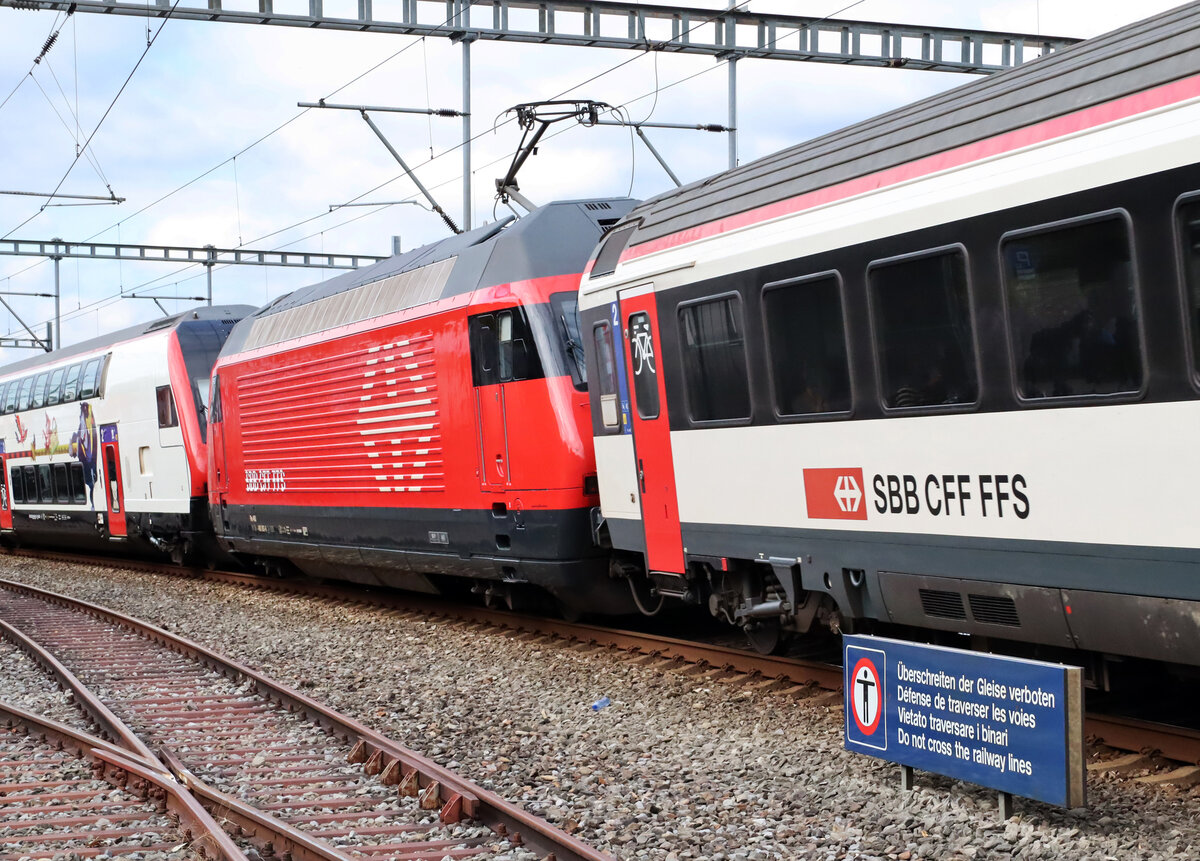 Lok-Sandwich: Re 460 in Original-Farbgebung fährt von Chur in Richtung Zürich durch den Bahnhof Richterswil. Die doppelstöckige Wagengarnitur gehört zum Zug, das einstöckige Wagenmaterial zum so genannten Modul. Der Fotograf steht ausserhalb des Gleisbereichs. Richterswil, 28.9.2025