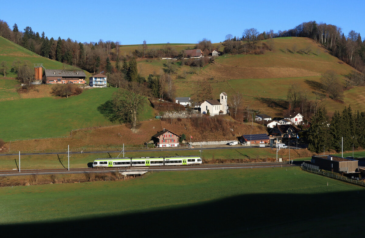 Lokalverkehr durch die Hügellandschaft Langenthal - Huttwil -Wolhusen am letzten Tag des Jahres 2021. BLS NINA 525 030 in Hüswil, 31.Dezember 2021 