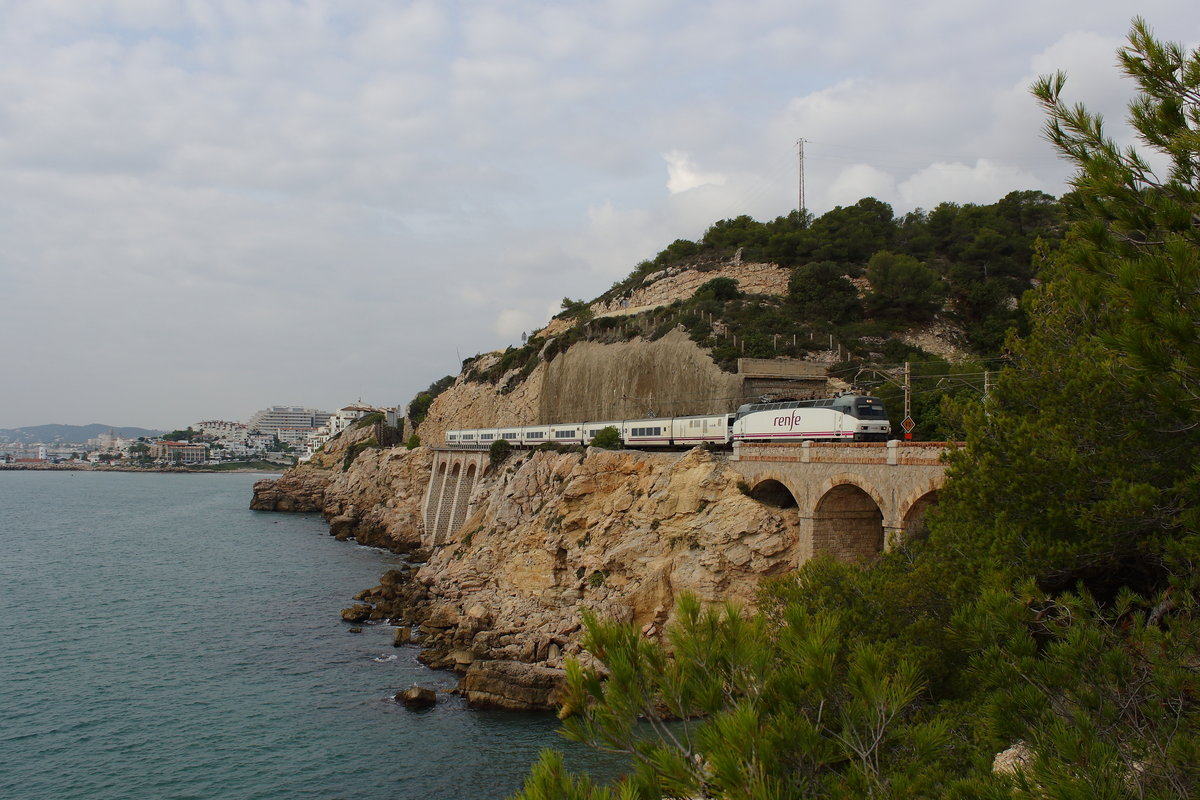 Lokbespannter Talgo mit der 252-Elok auf der Küstenstrecke zwischen Tarragona und Bacelona. Gesehen am 18.10.2016 an der felsigen Steilküste nahe Sitges. 